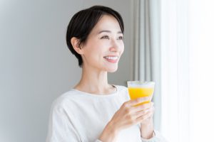 オレンジジュースを持つ女性